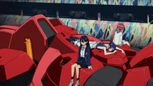 a girl sits on top of a red robot