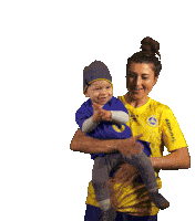 a woman in a yellow admiral shirt is holding a child