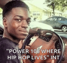 a man is sitting in a car with a steering wheel and a quote that says `` power 106 where hip hop lives '' .