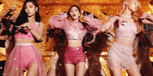 a group of women in pink outfits are dancing on stage