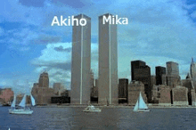 a couple of sailboats are floating in front of two skyscrapers .
