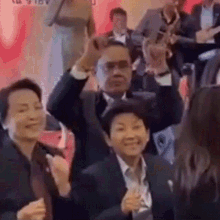 a group of people in suits and ties are dancing in a room .
