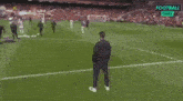 a man stands on a soccer field next to the name jurgen klopp