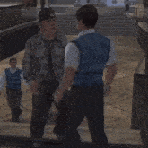 a man in a baseball cap is hugging a man in a blue shirt