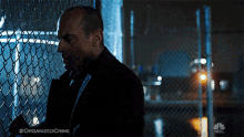 a man standing behind a chain link fence with the hashtag organized crime