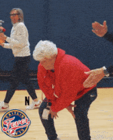 a woman in a red sweatshirt is kneeling down in front of a gaitlin fever logo
