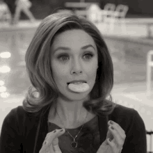 a woman is sticking her tongue out while holding a donut in her hand