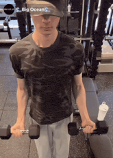 a man wearing a hat that says big oceans is lifting dumbbells