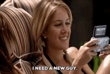 a woman is sitting on a couch playing a video game and says i need a new guy .