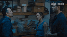 a man pointing a gun at a woman with who 's this written in the corner