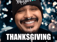 a man with a beard and a nose ring is smiling with the words thanksgiving written below him .