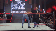 two wrestlers in a ring with a sign that says impact