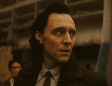 a close up of a man in a suit and tie looking at the camera .