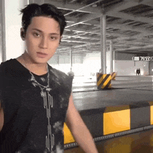 a young man in a black shirt is standing in a parking lot