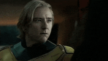 a man with blonde hair is wearing a yellow and green costume