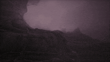 a dark cave with a purple sky and a statue in the foreground