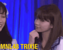 a girl with long hair and bangs is smiling and looking at the camera with the words mnl48 trixie above her .