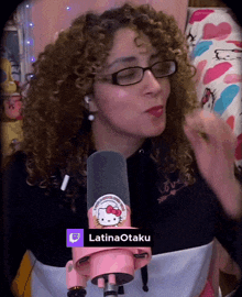 a woman with curly hair is wearing glasses and a hello kitty sticker