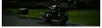 a close up of a person riding a motorcycle on a grassy field .
