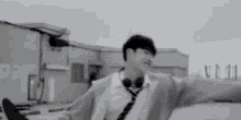 a young man wearing headphones and a tie is standing on a rooftop .