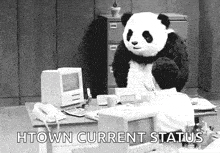 a panda bear is standing over a man sitting at a desk .