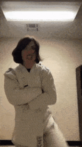 a woman in a white karate uniform with the letter s on the front