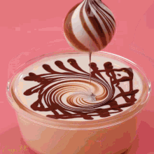 a chocolate swirl is being poured into a cup of milk