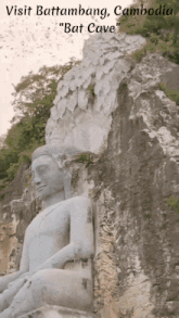 a statue of a buddha sits on a rocky cliff with the words visit battambang cambodia " bat cave " below it