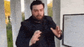 a man with a beard is standing in front of a white board with a drawing on it .