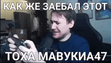 a man is sitting in a chair holding a video game controller in his hands .