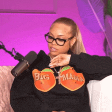 a woman wearing glasses and a black sweatshirt that says big mama