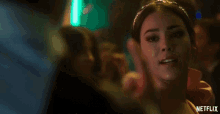 a woman wearing a headband and a red dress is smiling and giving a middle finger .