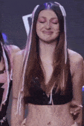 a woman with long hair is wearing a black crop top and pink and white extensions .