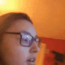 a woman wearing glasses is smiling and looking at the camera .