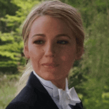 a woman is wearing a tuxedo and bow tie .