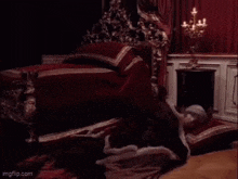 a woman is laying on the floor in a room next to a bed and a chair .