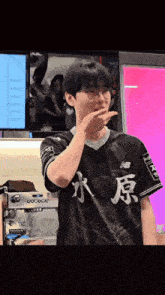 a man wearing glasses and a black shirt with chinese writing on it