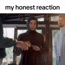 a woman in a hijab is shaking hands with another man