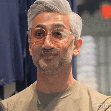 a man wearing glasses and a netflix shirt looks at the camera