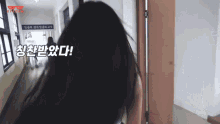 a woman is walking down a hallway with a sign that says ' a ' on it