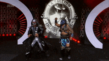 two wrestlers are standing in front of a logo that says la talacion