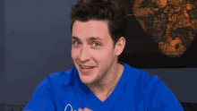 a man in a blue shirt is making a face in front of a map