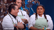 a group of chefs are standing in front of a wall of pots and pans with a nbc logo in the corner