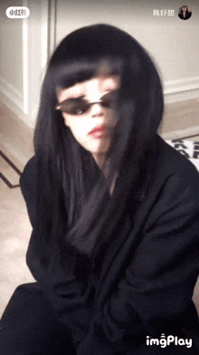 a woman with long black hair is wearing sunglasses and a black jacket .