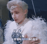 a man wearing a white feathered outfit has a star on his chest