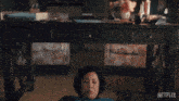 a woman wearing headphones is sitting in front of a netflix logo