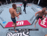 two men are fighting in a ufc ring with a monster energy drink in the background .