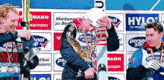 a man is holding a trophy in front of a wall that says hylo