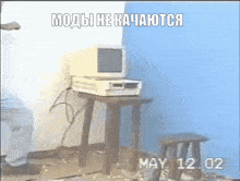 a computer monitor sits on a small table with the date may 12 2002