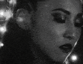 a close up of a woman 's face in a black and white photo